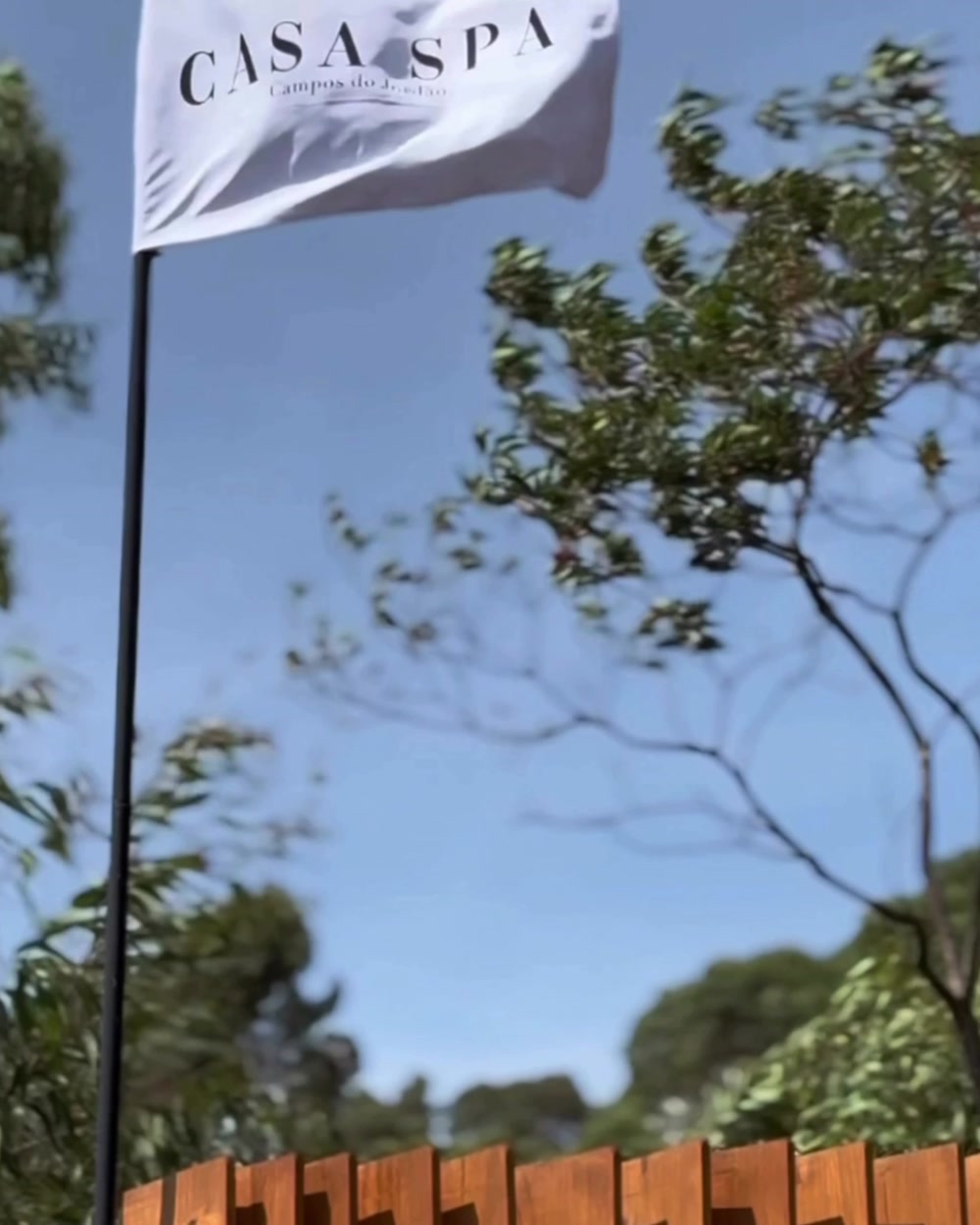 Bandeira da Casa Spa ao lado do deck, em dia claro